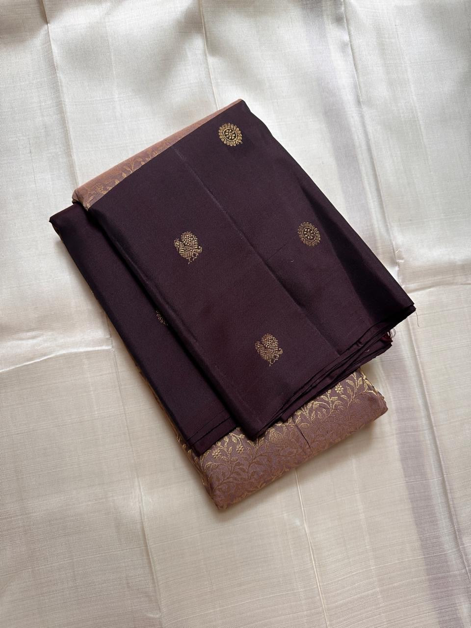Mauve Mayil – Pure Kanchipuram Silk Saree with Plum Body & Dusty-Rose Pallu
Deep plum silk adorned with delicate golden buttas.
Broad antique zari borders with kattam.
Dusty-mauve pallu in intricate vine jaal. Silk Mark Certified, delivery in 2 weeks