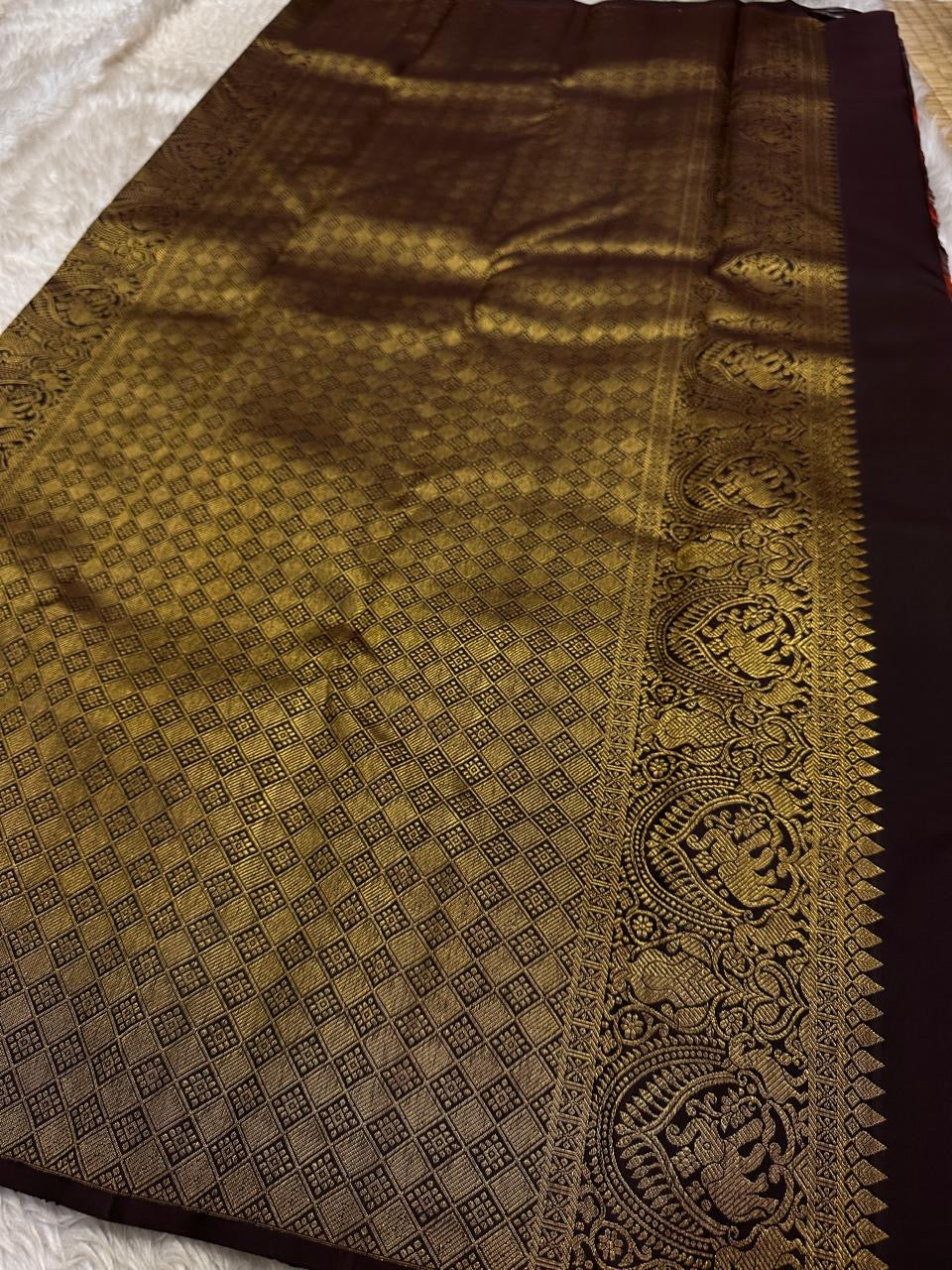 Sudar Mayil – Radiant Burnt Orange Pure Kanchipuram Silk Saree
Lustrous burnt orange body adorned with intricate gold vine jaal.
Broad deep plum borders gleam with antique zari artistry.

Silk Mark Certified, delivery in 2 weeks
