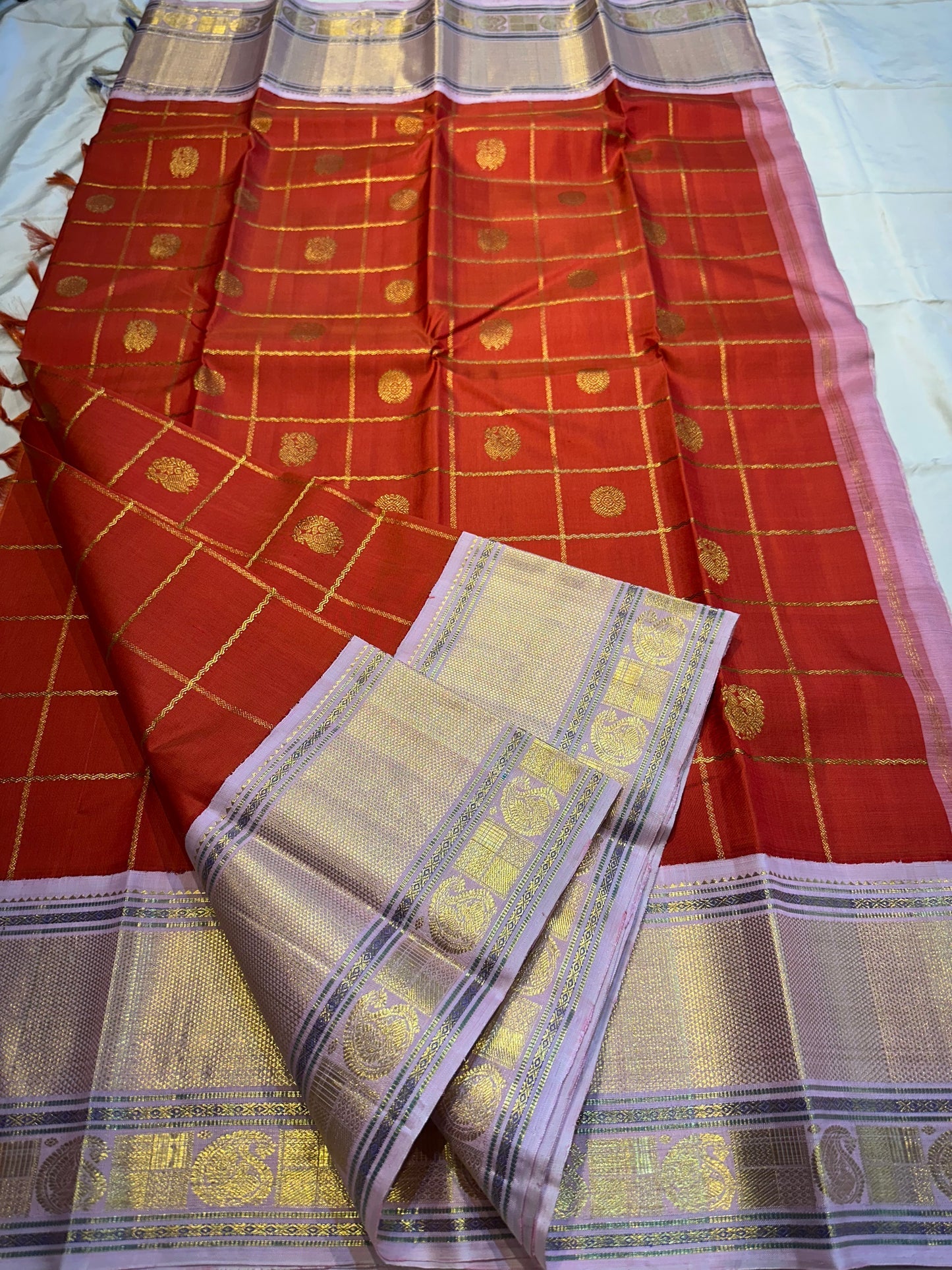 Bhargavi
Striking Orange Kanchipuram Silk Saree with Unusual Lavender Border 💜
Zari Kattam Neli Checks with Kamalam & Mayil Motifs Across the Body 🪷🦚
Broad Arai Maadam Border Flanked by Diamond & Paisley Motifs, Grand Zari Pallu ✨