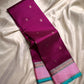 A regal magenta silk with intricate  zari buttas scattered delicately across the body. The border is a stunning blend of soft pink and teal, featuring fine gold silver  zari weaving and temple motifs