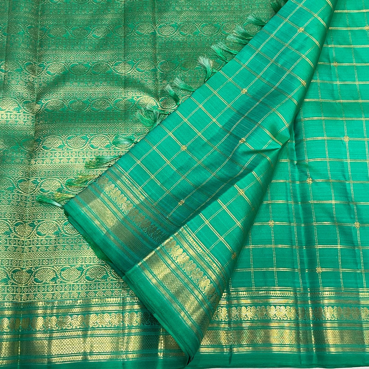 Double Muthu Seer zari lattice on a jade green Kanchi Pattu saree