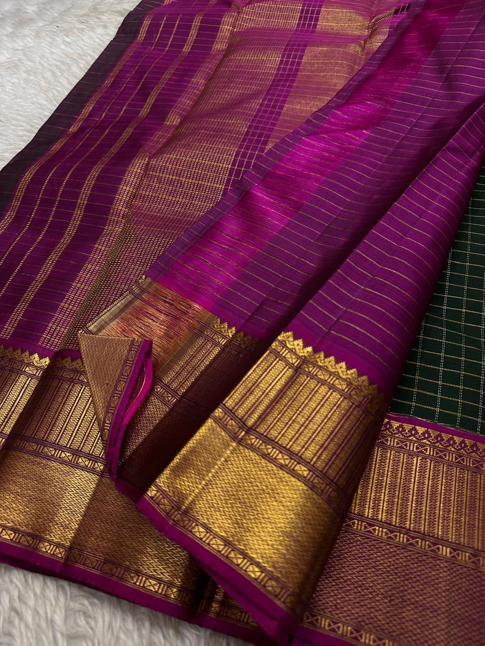 Pachai Zari Kattam – Pure Kanchipuram Silk Saree
Deep Emerald Green Body with Gold Zari Checks
Broad Golden Border with Magenta Highlights & Temple Motifs
Royal Magenta Pallu with Lustrous Zari Stripes

Silk Mark Certified, delivery in 2 weeks