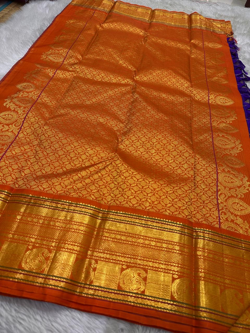 Raga Priya ✨ – Pure Kanchipuram Silk Saree
Royal Purple Body with Zari Kattam & Mayil Chakram Buttas
Sunset Orange Korvai Border in Neli Vanki Zari Pattern
Grand Orange Brocade Pallu with Intricate Weaves
Silk Mark Certified | Fall & Pico Done |