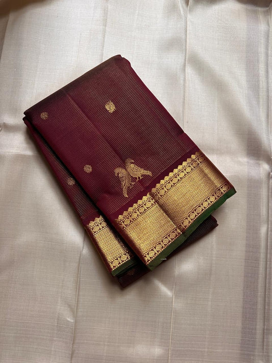 Kili Brown Maroon ✨
Vairaoosi Pure Silk Kanchipuram Saree
With Gold Kili (Parrot) Motifs
Vanki Neli Border with Arai Maadam & Rudhraksham Pet
Opulent Grid Zari Pallu & Matching Blouse