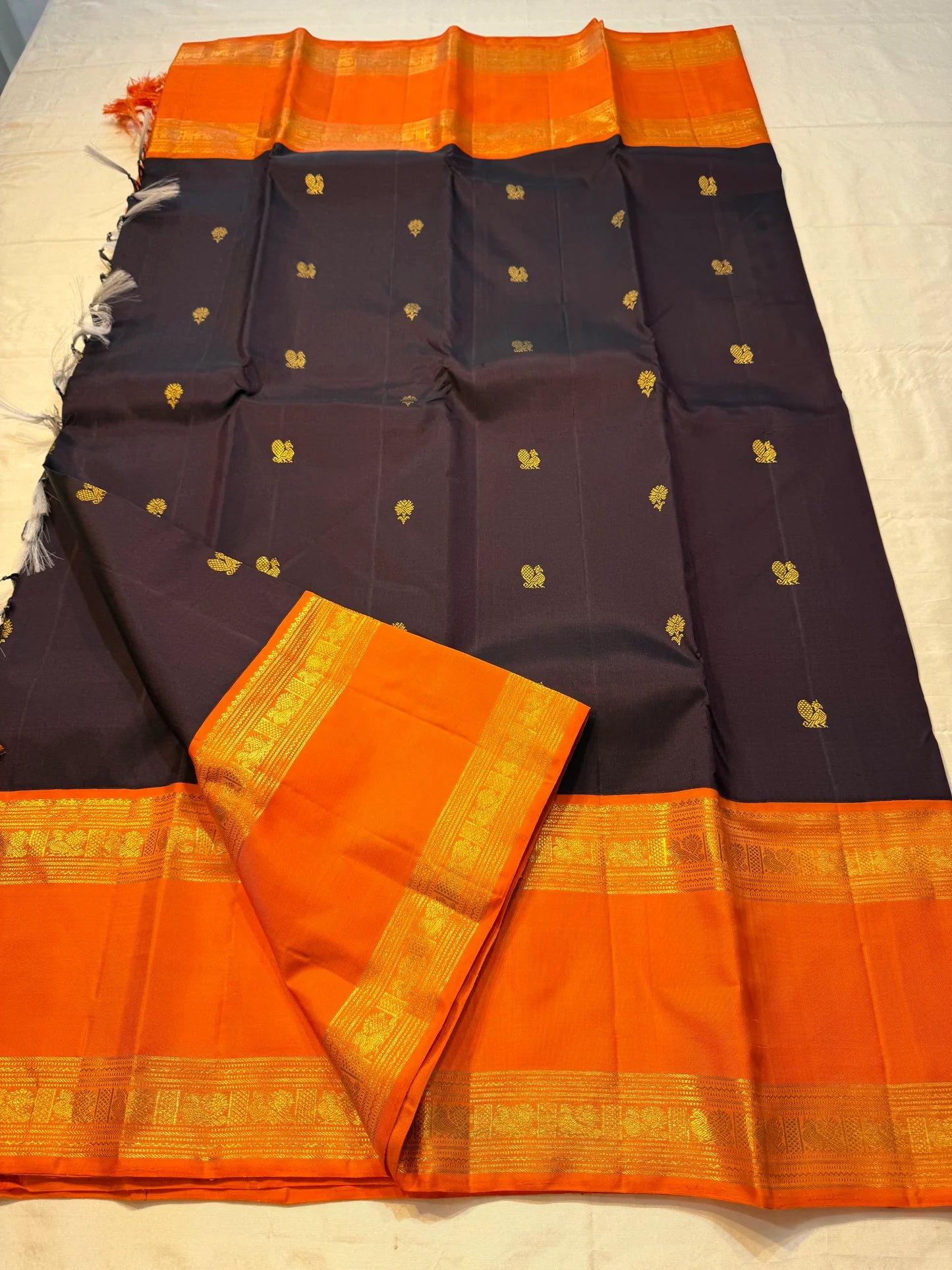 Auberge Kesar Glow Butta — Pure Kanchipuram Silk Saree
Aubergine Body with Gold Zari Buttas & Kesar-Orange Border
Silk Mark Certified • Free Shipping within USA • Ships in Two Weeks