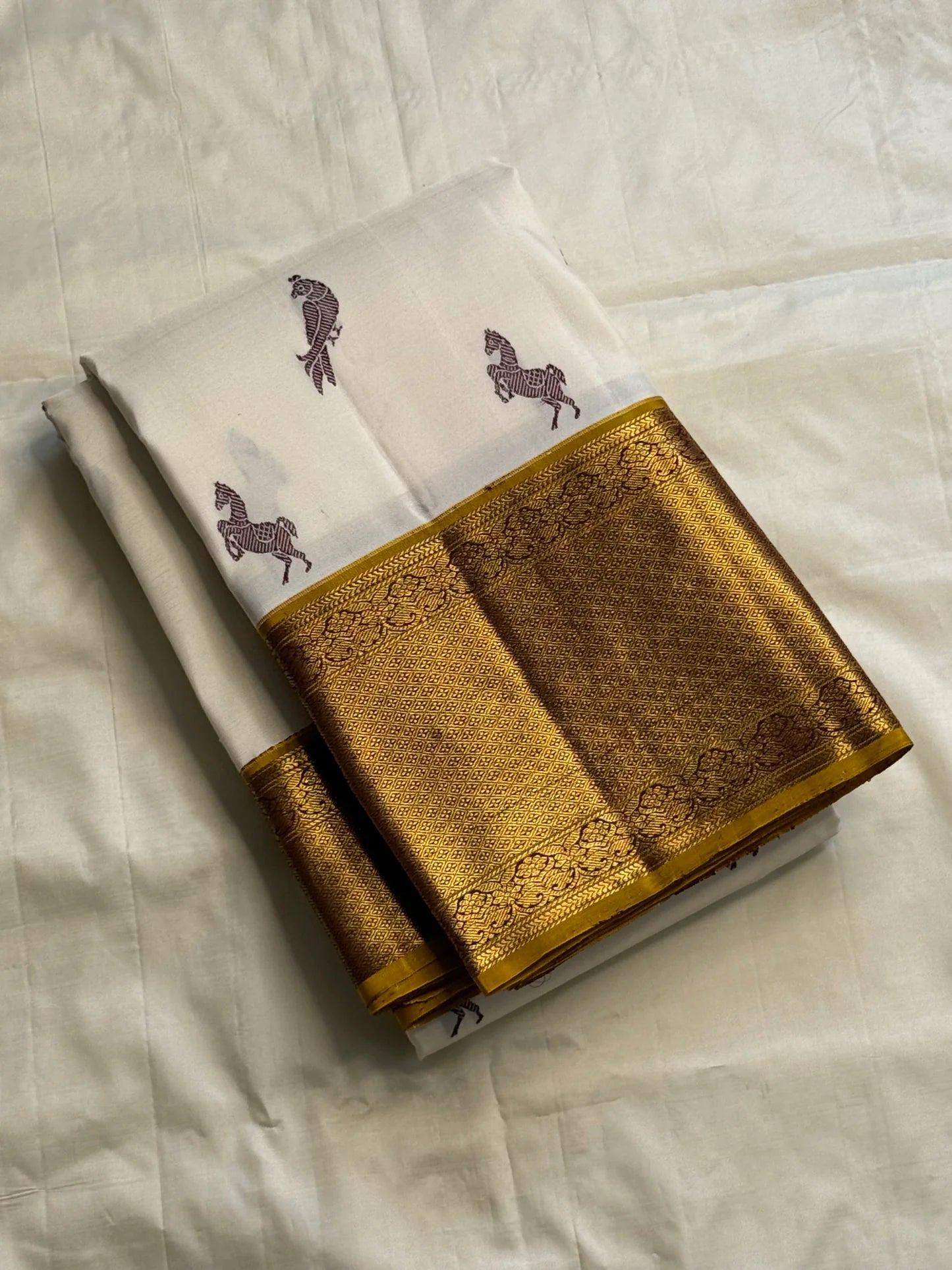 Close-up of Ashwa Pakshi ivory Kanchipuram silk saree showing horse and parrot motifs with gold zari border