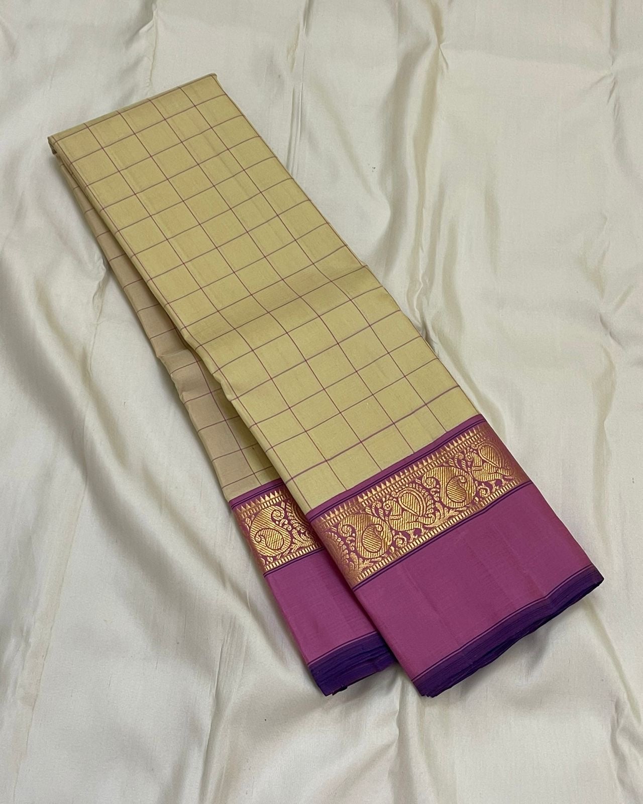Lotus Kattam — Pure Kanchipuram Silk Saree
Butter-cream body with fine rose-pink kattam checks ✨
Rani-magenta zari border with lotus vines & paisley motifs 💖
Silk Mark Certified ✅ Free USA Shipping ✅ Ships in Two Weeks ✅