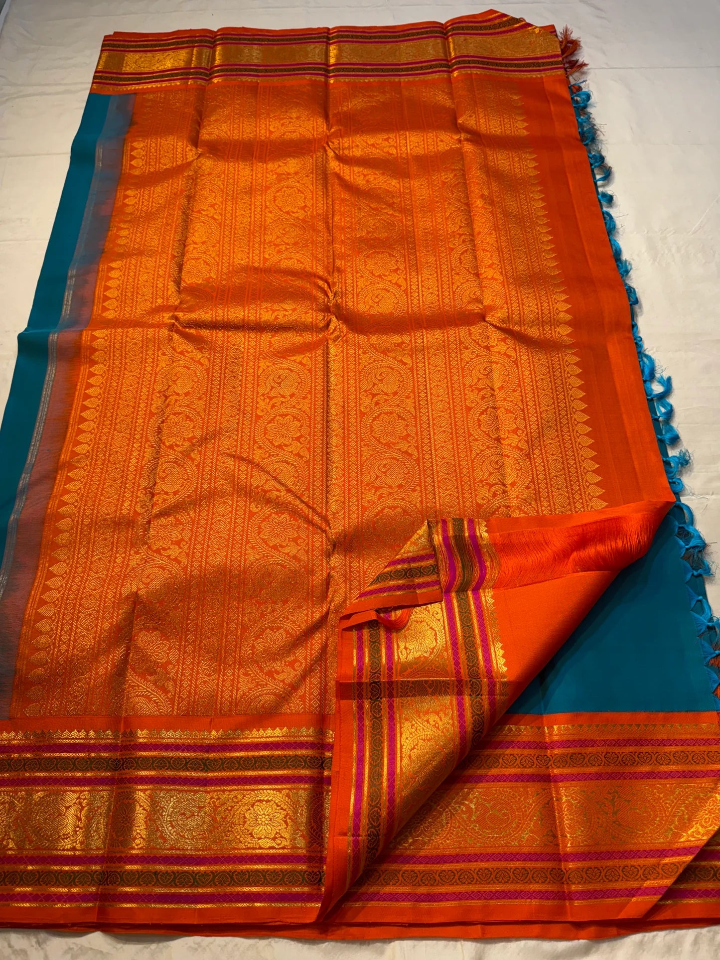 Aazhi Teal — Pure Kanchipuram Silk Saree
Teal body with silver-zari rosette buttas and korvai kavi–magenta borders in gold-zari brocade.
Silk Mark Certified • Free Shipping within USA • Ships in Two Weeks ✅