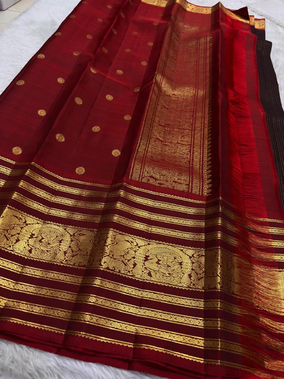Close view of fine vertical zari filaments and gold buttas on deep plum Kanchipuram silk