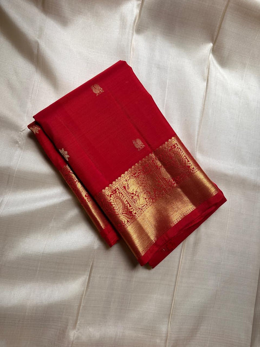 Dia ✨ – Chilli Red Pure Kanchipuram Silk Saree
Allover Gold Zari Floral Buttas on Body
Broad Elephant–Peacock (Gaja–Mayil) Zari Panel Border
Rich Red & Gold Brocade Pallu with Intricate Weaves
Silk Mark Certified | Fall & Pico Done | Blouse Stitching $30