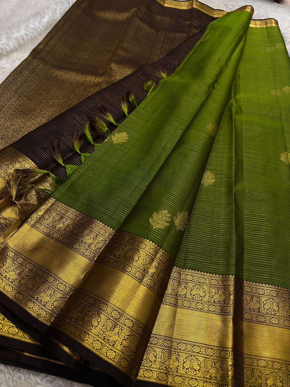 Forest Gold – Pure Kanchipuram Silk Saree
Leaf-green body with fine pin stripes.
Zari leaf buttas for subtle sparkle.
Coffee-maroon korvai border in antique gold.

Silk Mark Certified, delivery in 2 weeks