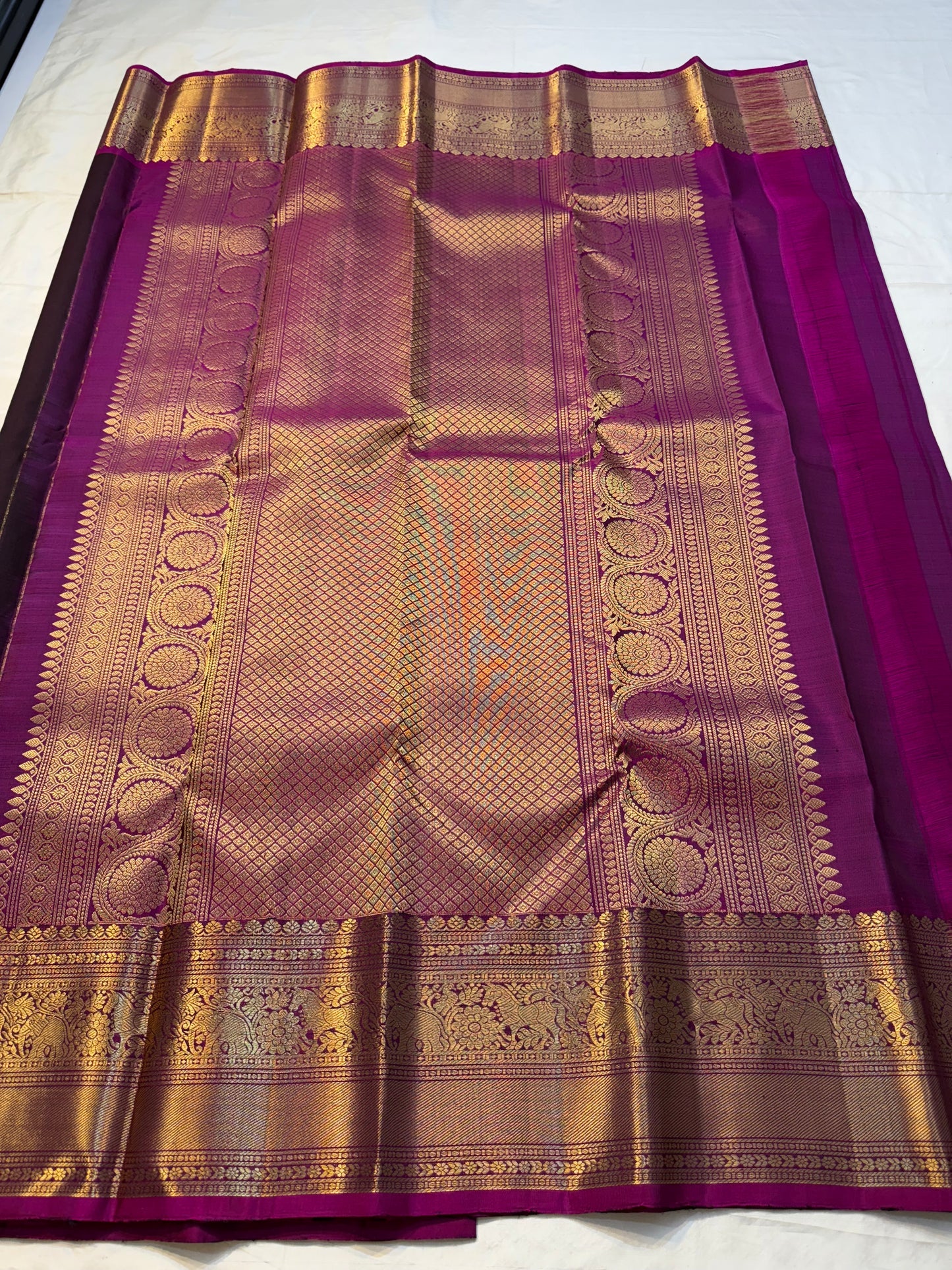 Jamun Purple Rani — Kanchipuram Pure Silk

Deep jamun-purple body with zari floral buttas

Rani-magenta korvai borders with elephant procession

Opulent brocade pallu with diamond jaal & circular medallions

Silk Mark Cert| Free Shipping within USA