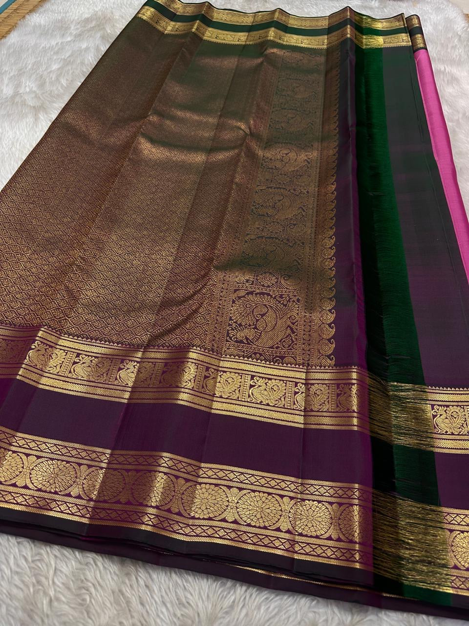 Anvitha – Magenta & Pink Shot Kanchipuram Pure Silk Saree
Glowing dual-tone silk body in radiant magenta and pink
Paired with a rich brown rettapet border featuring peacocks & floral vines in gold zari
