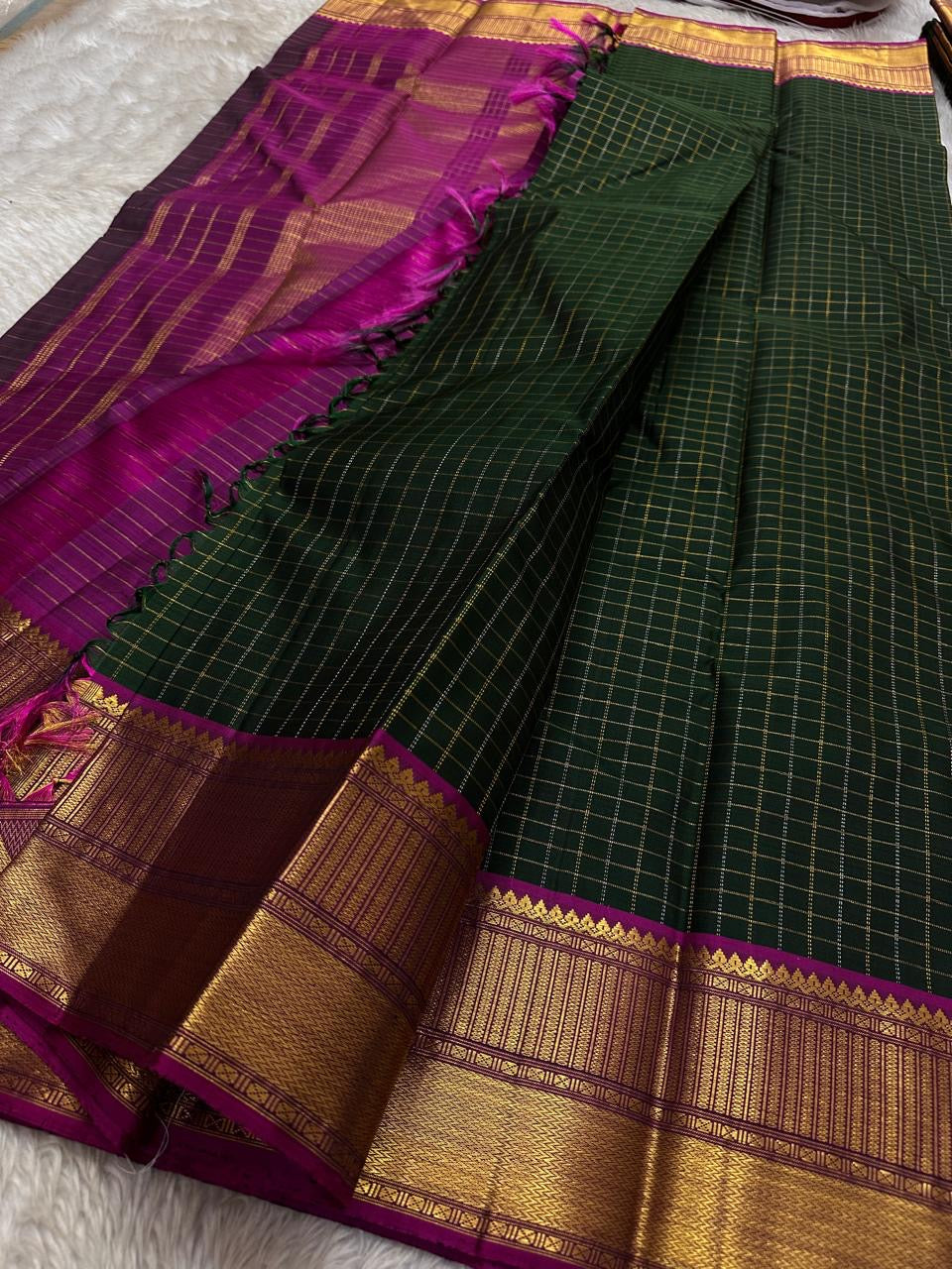 Pachai Zari Kattam – Pure Kanchipuram Silk Saree
Deep Emerald Green Body with Gold Zari Checks
Broad Golden Border with Magenta Highlights & Temple Motifs
Royal Magenta Pallu with Lustrous Zari Stripes

Silk Mark Certified, delivery in 2 weeks