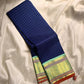 A striking blend of tradition and bold design, this navy blue Kanchipuram silk saree features delicate grid-like checks across the body. What sets it apart is the vibrant mint green and gold zari border, intricately woven with paisley and floral motifs