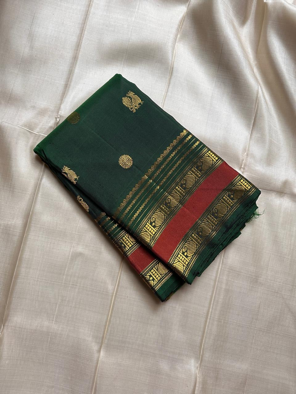Minnal ✨ – Forest Green Kanchipuram Pure Silk Saree
with Radiant Gold Coin Buttas 🌸
Rust Korvai Varisaipet Zari Border
Grand Green Pallu with Gold Stripes & Panels