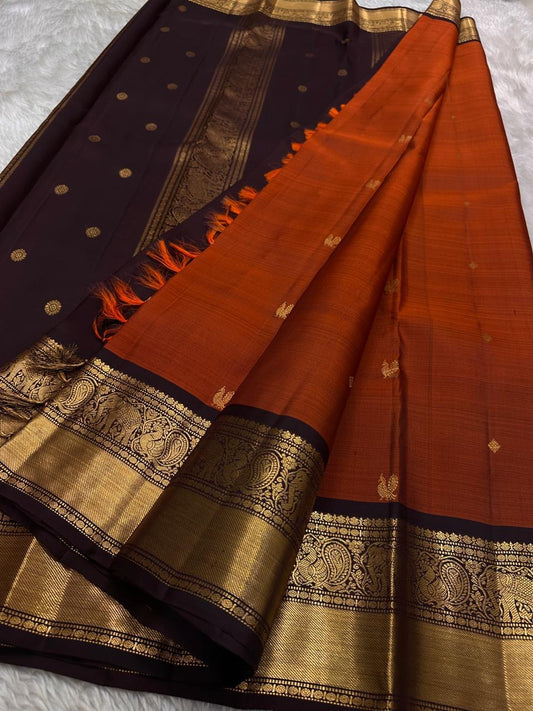 Pure silk kanchipuram  deep brown Zari kattam with a vibrant red tangerine orange Mayil border