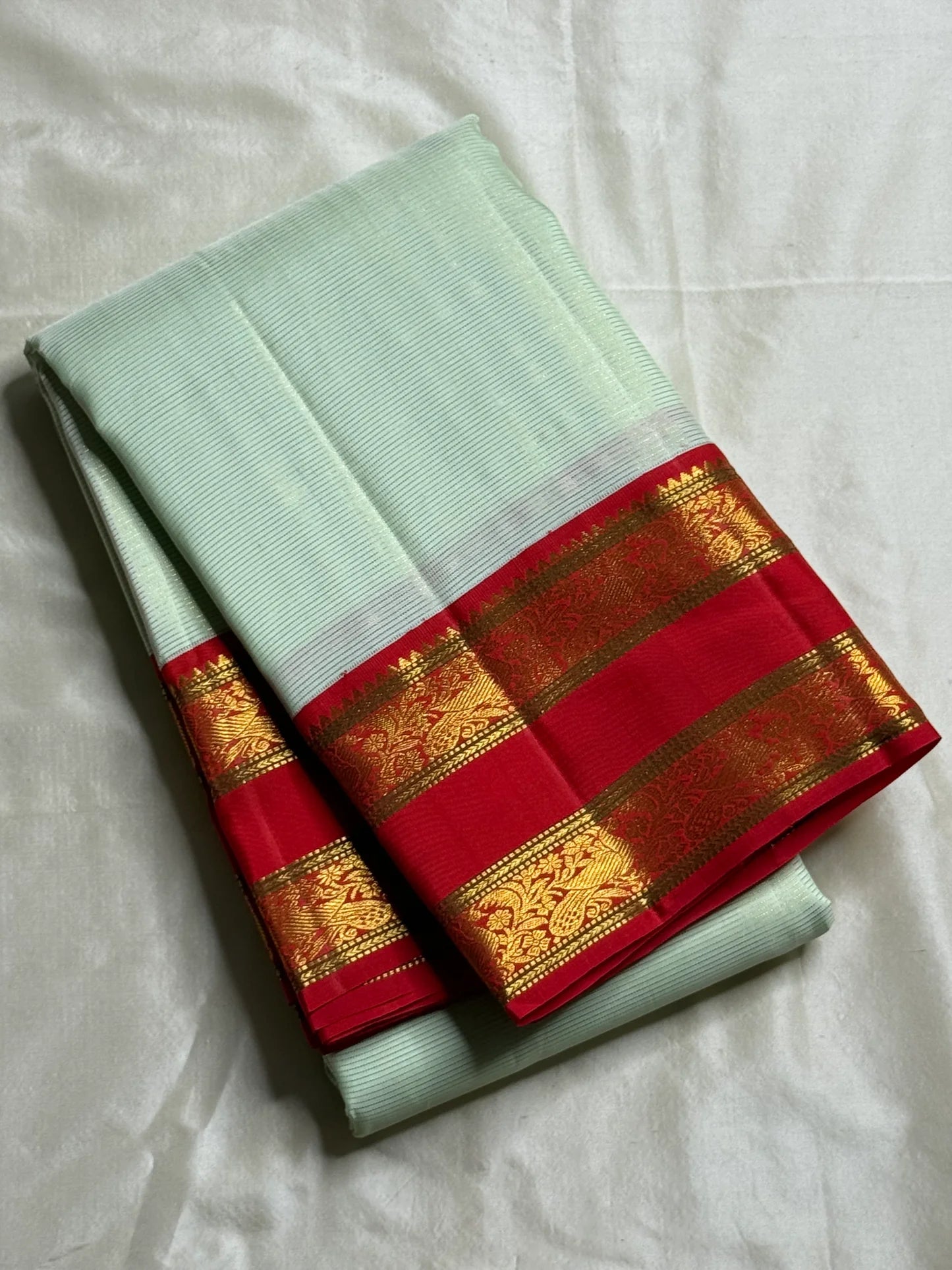 Scarlet Mist ✨ – Pastel Mint Vairaoosi Kanchipuram Pure Silk Saree
Korvai Scarlet-Red Border with Rich Zari Vines & Green Selvedge
Grand Red Pallu with Traditional Bird Buttas & Brocade Panels
Contrast Red Blouse fabric