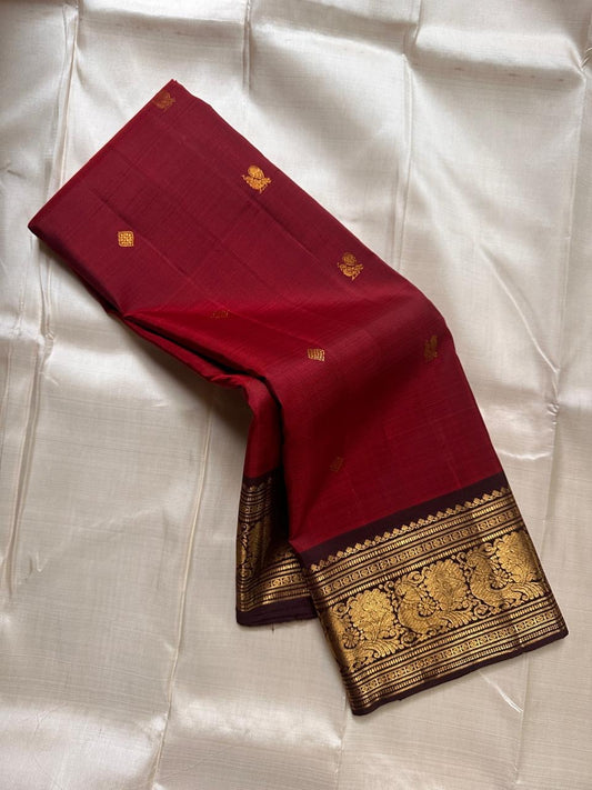 Sienna Red Mayuri Butta — Pure Kanchipuram Silk
Sienna-red body with zari mayuri buttas & antique gold border
Contrast coffee-brown pallu in rich zari jaal • Silk Mark Certified • Free USA Shipping