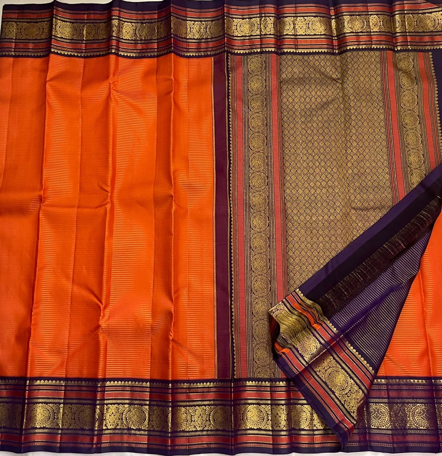 Kesari Annapakshi Chakram
Pure Kanchipuram Silk Saree – Vibrant Kesari Orange Body with Gold Zari Chakram Buttas
Deep Purple Korvai Borders with Majestic Annapakshi & Floral Motifs
Grand Purple Zari Pallu. Silk mark certified , ships in 2 weeks