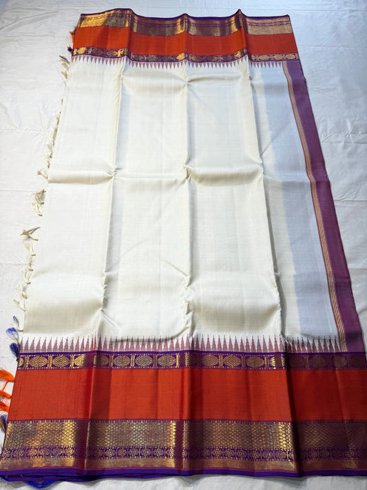 Ivory Temple Glow – Pure Kanchipuram Silk Saree
Ivory Body with Saffron Temple (Gopuram) pillayar moggu 
Amethyst-Purple Zari Border with Floral Vines 🌸
Grand Purple Pallu in Rich Zari

Silk Mark Certified, delivery in 2 weeks