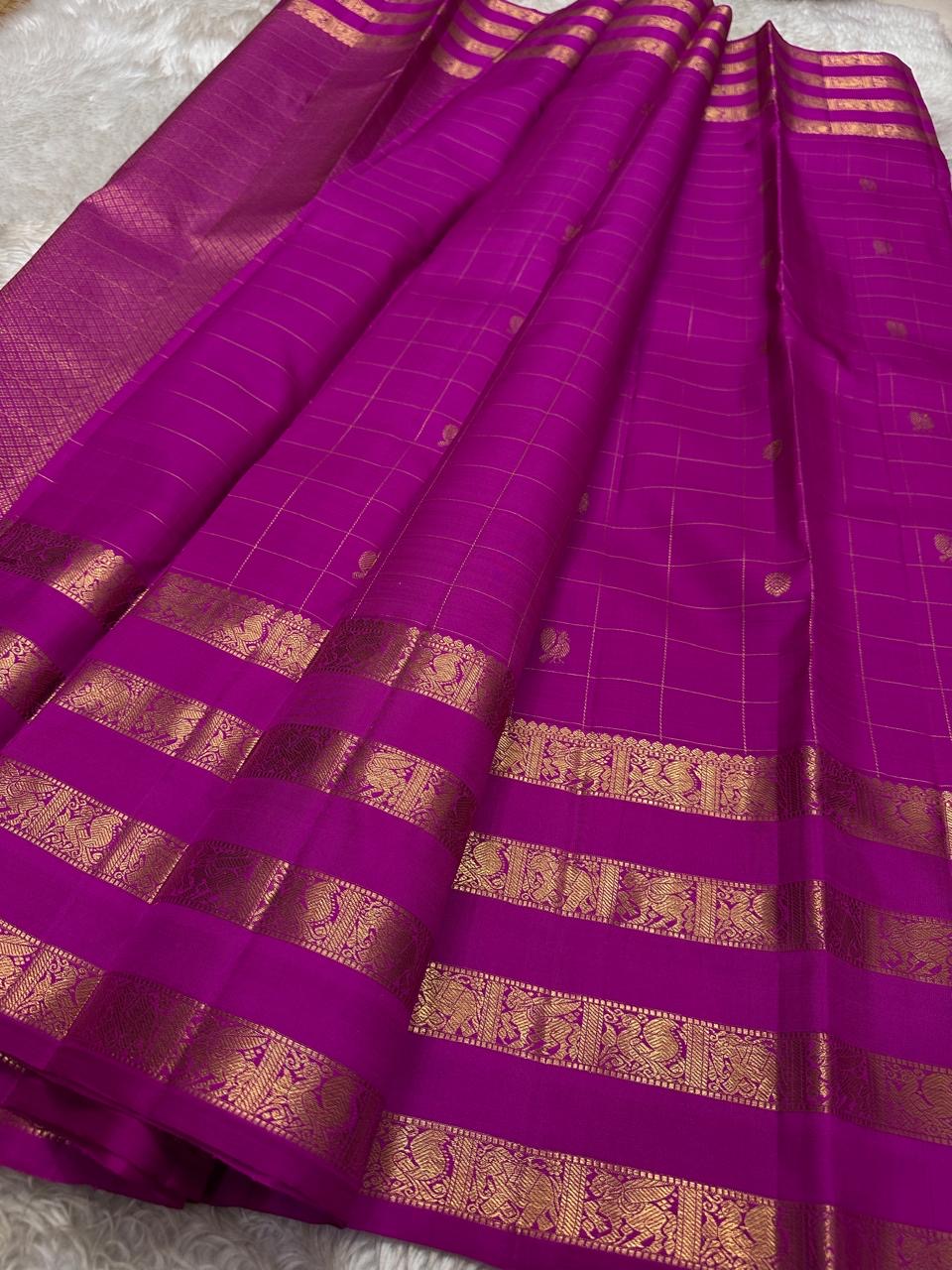 vasantham  Fuchsia pink – Handwoven Kanchipuram Silk Saree A poem in Fuchsia silk. The body glows in a serene vibrant Fuchsia, softly accented by delicate gold vertical lines and dainty gold zari buttas that glint like little blessings.