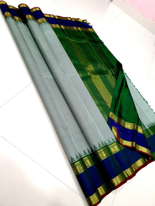 Podi Kattam Emerald Pillar Moggu – Pure Kanchipuram Silk Saree
Seafoam–Ice Blue Micro Checks with Korvai Emerald Green Border
Neelam Blue Panel & Gold Zari pillayar Moggu Motifs
Rich Emerald Zari-Striped Pallu | silk mark certified Saree ships in two week
