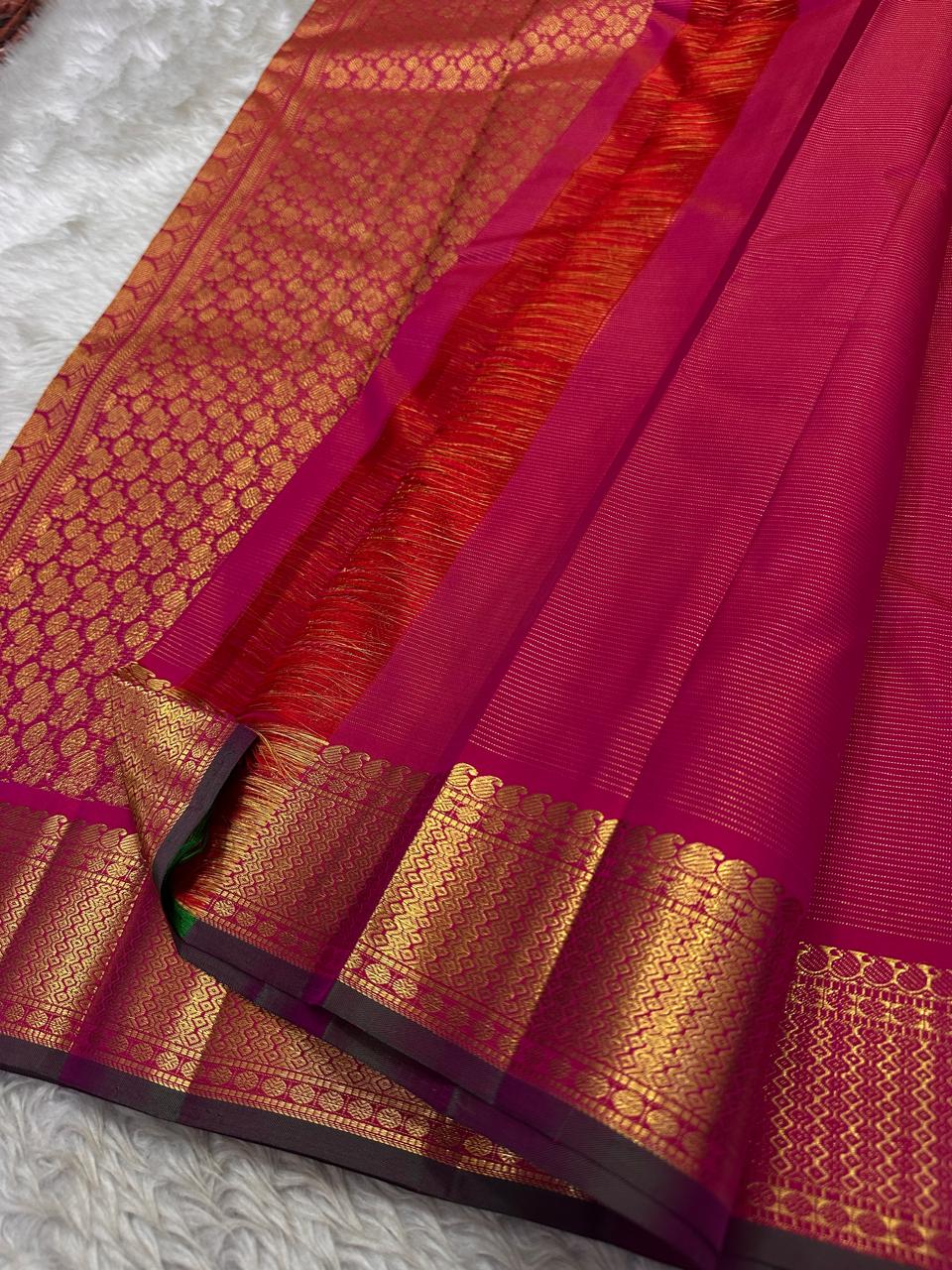 Rani Kili Butta Vairaoosi — Pure Silk Kanchipuram Saree
Rani-pink body with zari buttas & twin parrot motifs, antique-gold coin borders with emerald selvedge
Rich red-orange vairaoosi pallu with rosette brocade, matching blouse included
Silk Mark Cert