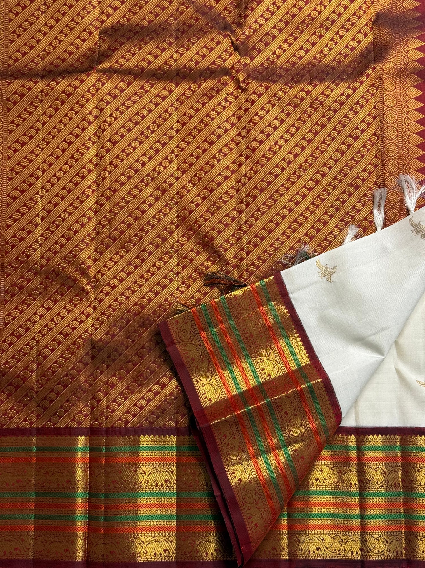 Parakkum Kili — Ivory Pure Silk Kanchipuram

Ivory body with fine zari coin buttas ✨
Rust-orange korvai borders with mayil & temple motifs 🌸
Grand rust-orange zari brocade pallu with tassels 🪔
Silk Mark Certified • Free Shipping USA • Ships in Two Weeks
