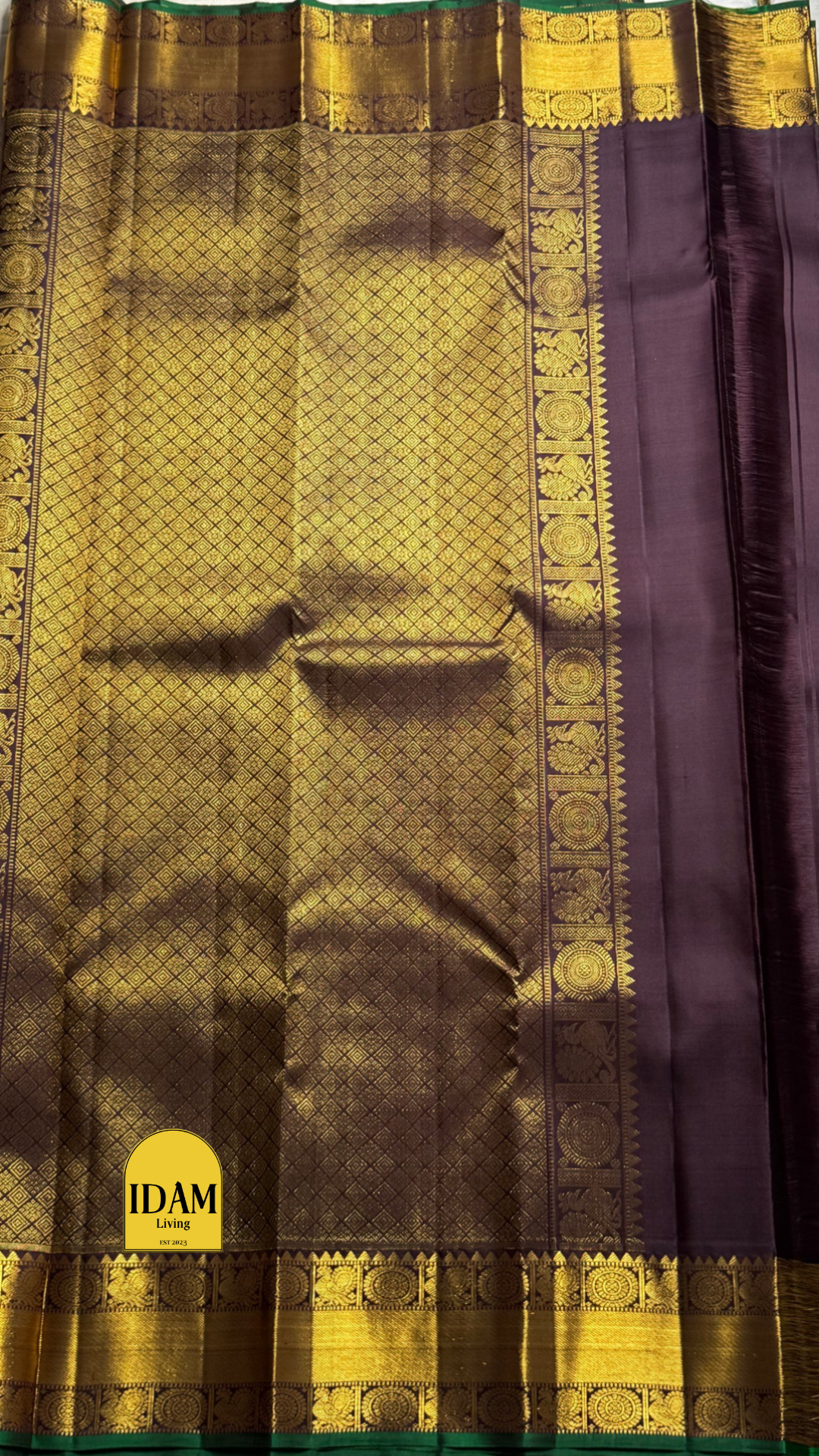 Tanaya features a regal mulberry mauve purple body adorned with golden kamalam and mayil buttas. Its elegant dual-tone border—coffee brown on top and emerald green below with rich temple-inspired zari work with medallions and florals woven, rich Pallu.