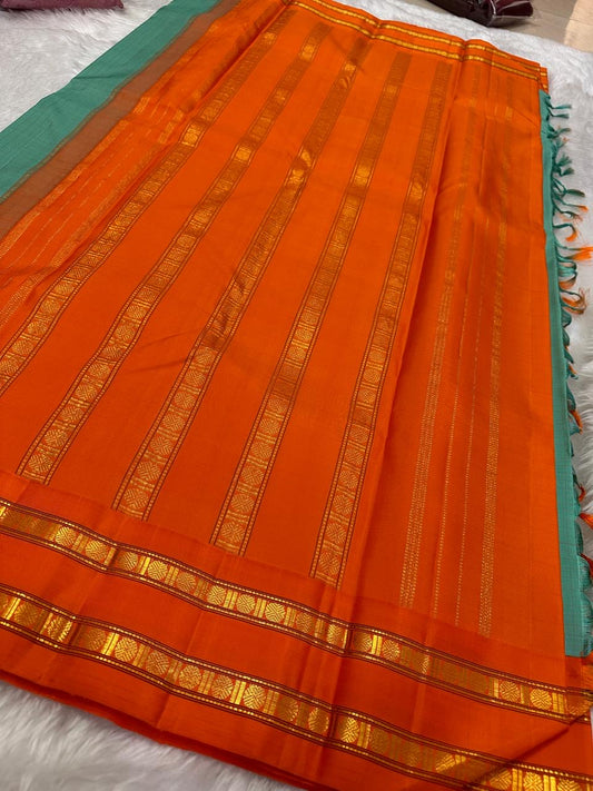 Sharvani blue sea green – sea green  Checked Silk Saree with an Orange red  shot color Zari Border & Vibrant Pallu A timeless silk saree featuring a cream body with delicate red checks, complemented by a striking churan orange  zari border pallu.