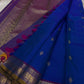 Sapphire Orchid celebrates the classic blue–purple pairing of Kanchi. The body is a rich sapphire/cobalt blue with tiny floral buttas in gold zari. A striking amethyst-purple korvai border and grid pavun Zari pallu Silk Mark Certified, delivery in 2 weeks