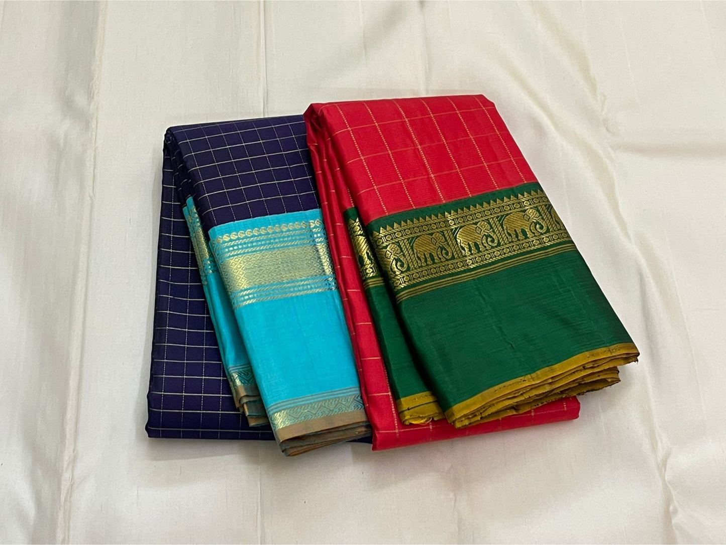 Indigo Teal Kattam – Pure Silk Kanchipuram Saree
Deep Indigo Body with zari Kattam Checks
Teal Contrast Korvai Border with maanga pet and mayil kann border, maanthulir selvedge  , silk mark certified -ships in two weeks