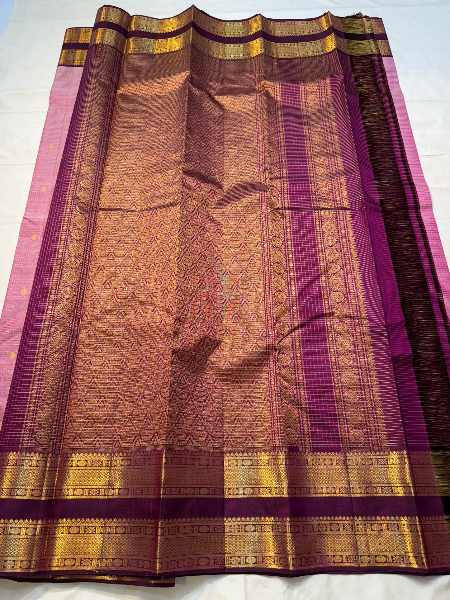 Rose Mist Zari Kattam — Kanchipuram Pure Silk

Blush rose-pink body with micro kattam (checks) in zari & scattered soorya-chakram buttas

Contrast mulberry purple korvai borders with rich gold zari detailing

Free shipping within USA silk mark certified