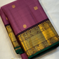 Tanaya features a regal mulberry mauve purple body adorned with golden kamalam and mayil buttas. Its elegant dual-tone border—coffee brown on top and emerald green below with rich temple-inspired zari work with medallions and florals woven, rich Pallu.