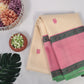 Ivory and lotus pink no-zari Kanchipuram silk saree draped over a chair, showing contrast pallu and tassels on a white background