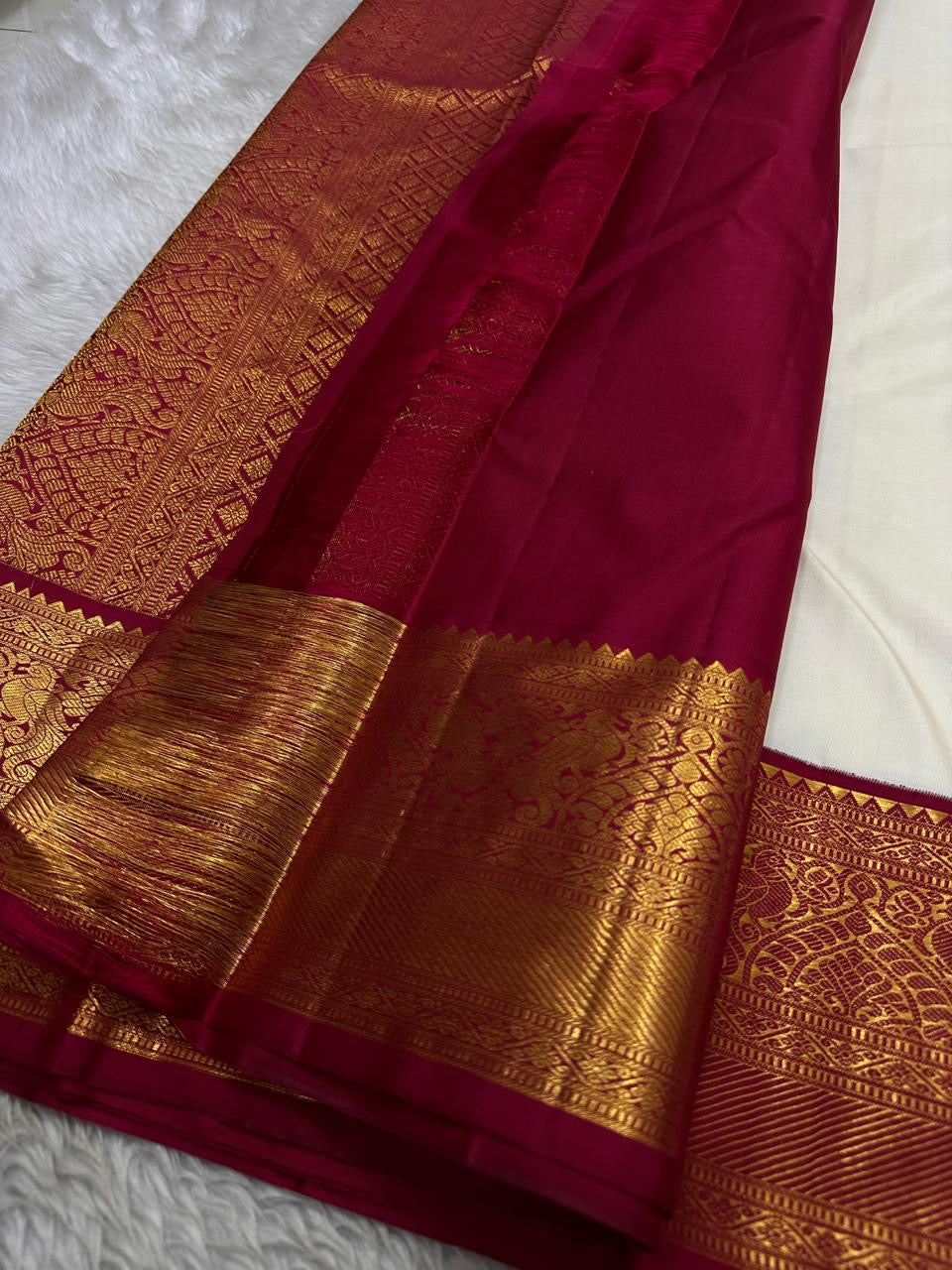 Ivory Mayil – White Mayil Butta Korvai Kanchipuram Silk Saree
Pure handloom silk | Ivory body with gold peacock buttas
Wine-maroon korvai border with peacock & floral zari motifs
Grand gold-zari brocade pallu | ships in two weeks
Silk Mark Certi