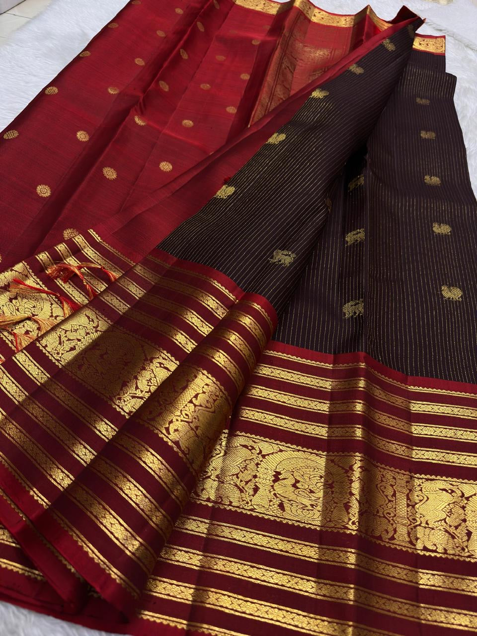 Gold zari pallu detail on a deep plum and Arakku red Kanchipuram silk saree