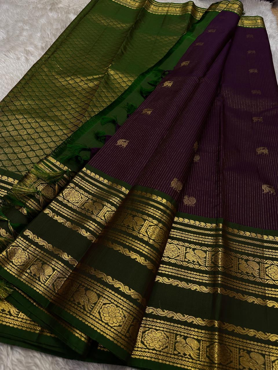 Radhe ✨
Plum Purple Oosi-Striped Kanchipuram Silk
Zari-Woven Yaali Motifs on the Body
Bottle-Green Rettapet Border with Peacocks
Grand Gold Zari Jaal Please | Silk Mark Certified