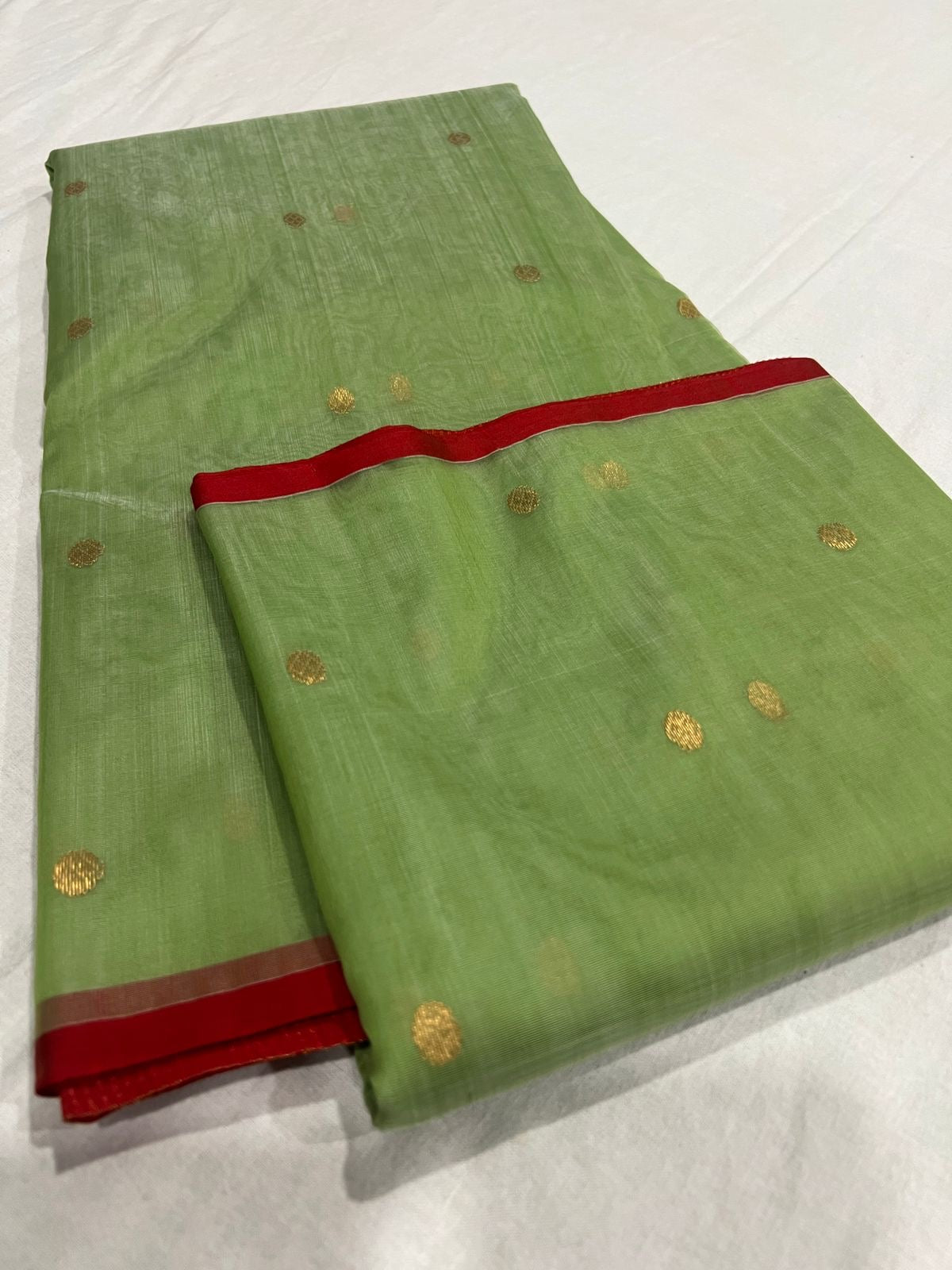 Green Chanderi Katan Silk saree showing translucent handloom body, red edging and zari pallu