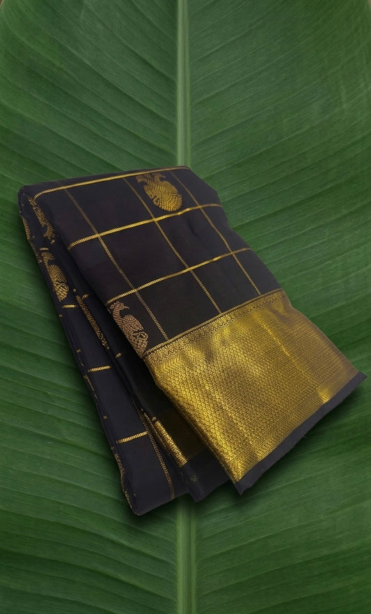 Pure silk midnight-toned Kanchipattu saree with structured zari kattam pattern and intricate Gandaberunda weaving