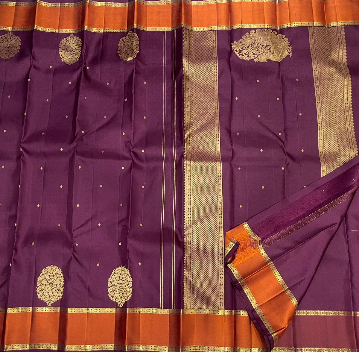 Ornate Mughal-inspired floral medallions on an aubergine Kanjivaram silk saree