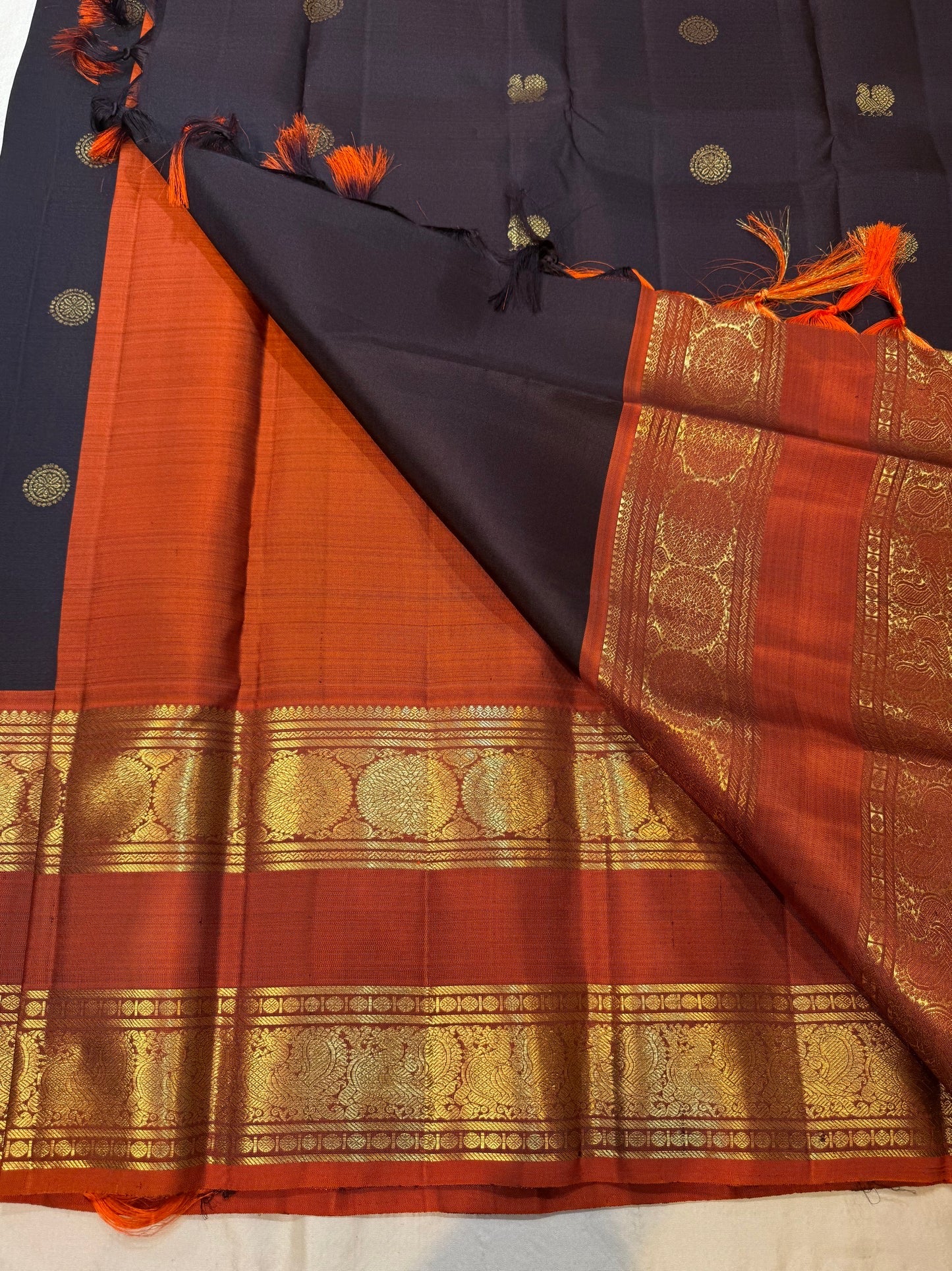 Folded view of dark charcoal and rustic cinnamon red rettapet Kancheepuram silk saree — Idam Living