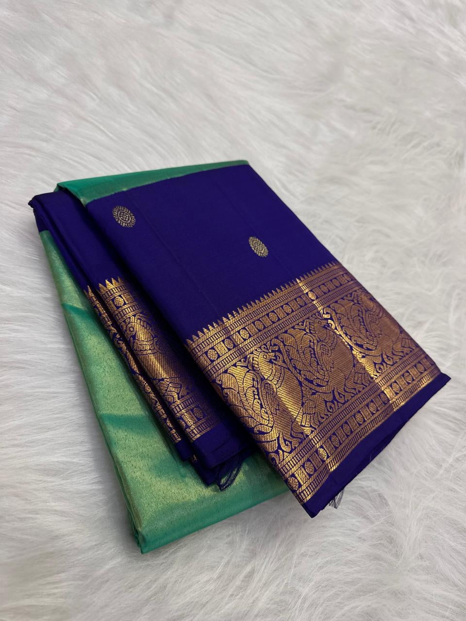 Close view of the tissue silk body showing mint green with gold shimmer and royal blue section with scattered oval gold butta