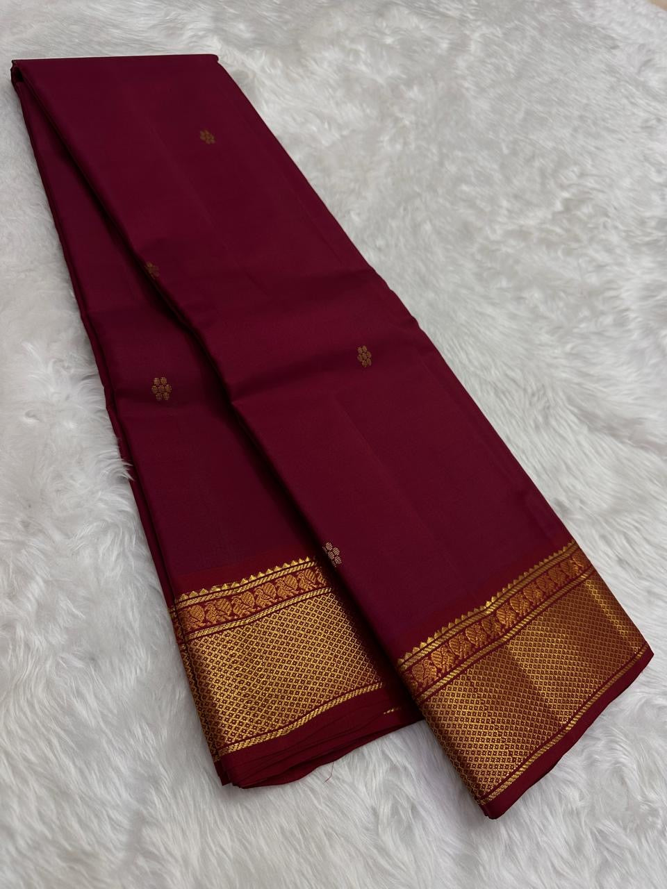 Close view of the arakku red silk body showing scattered Kamalam Butta lotus motifs in gold zari