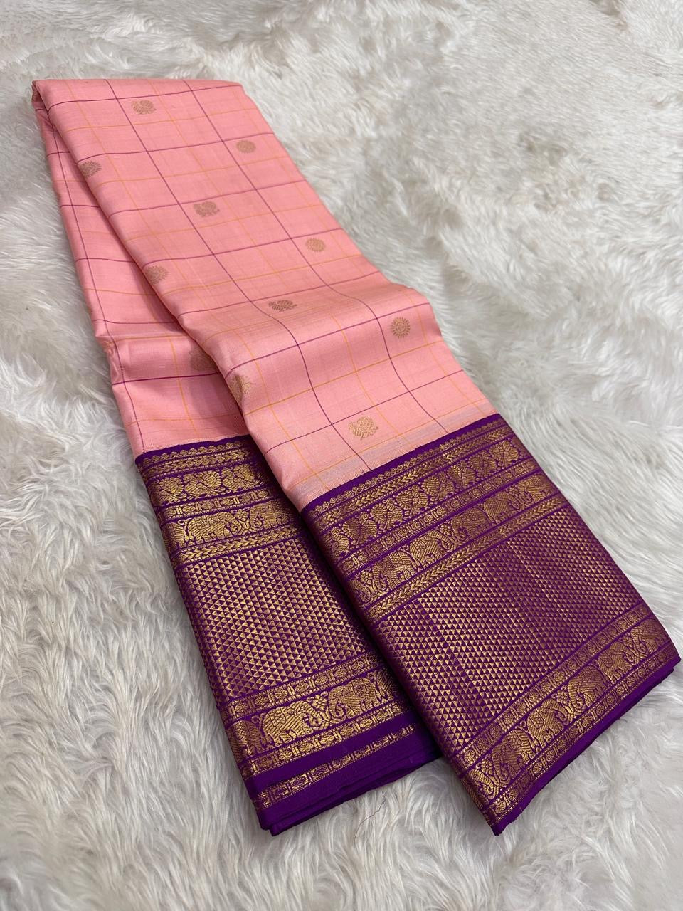 Full folded view of radiant pink Kancheepuram Zari Kattam saree showing Kamalam body and deep purple border