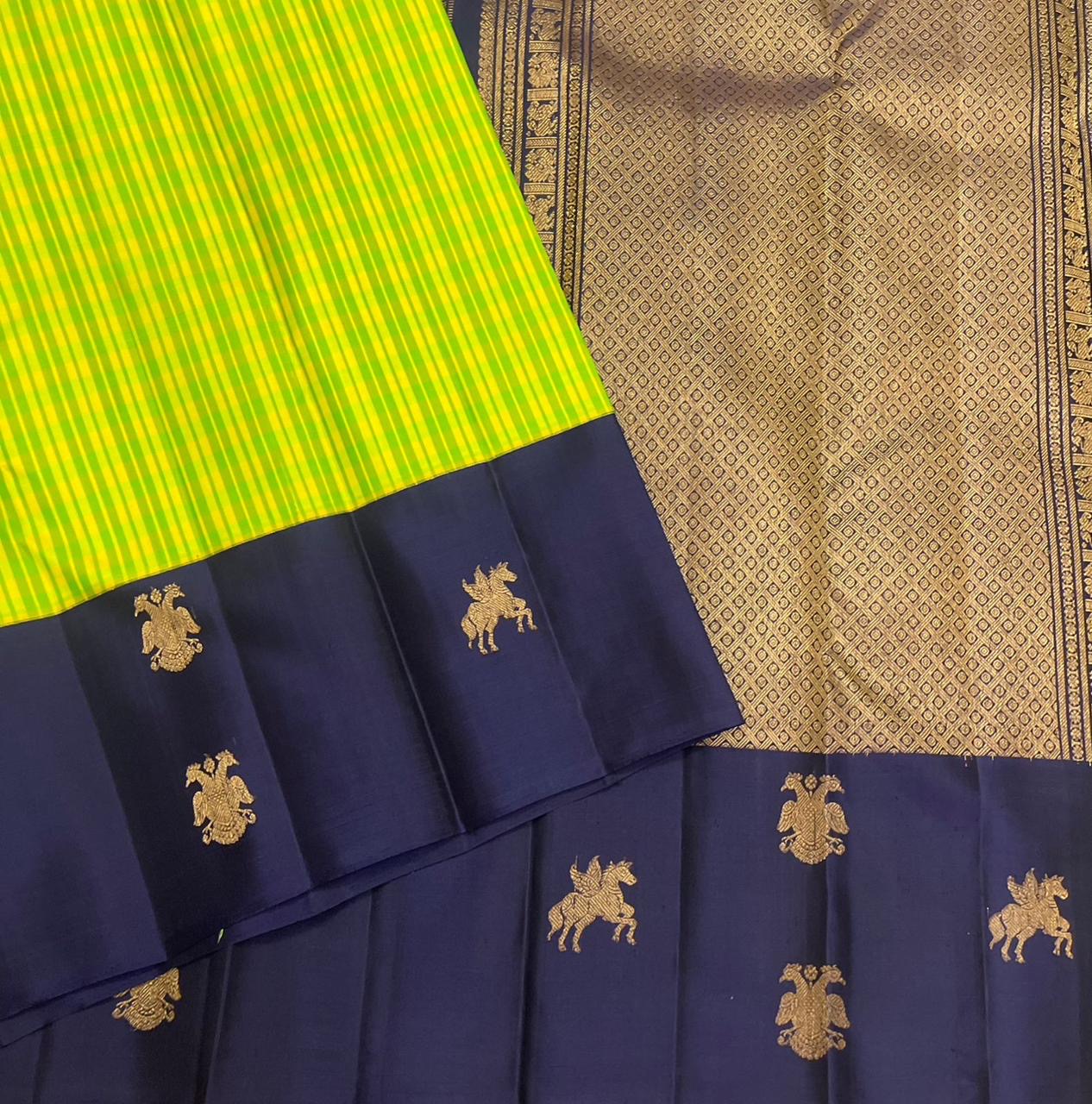 Gandaberunda and Kudhirai flying horse gold zari buttas on navy border of lime green Kanjeevaram saree — border detail