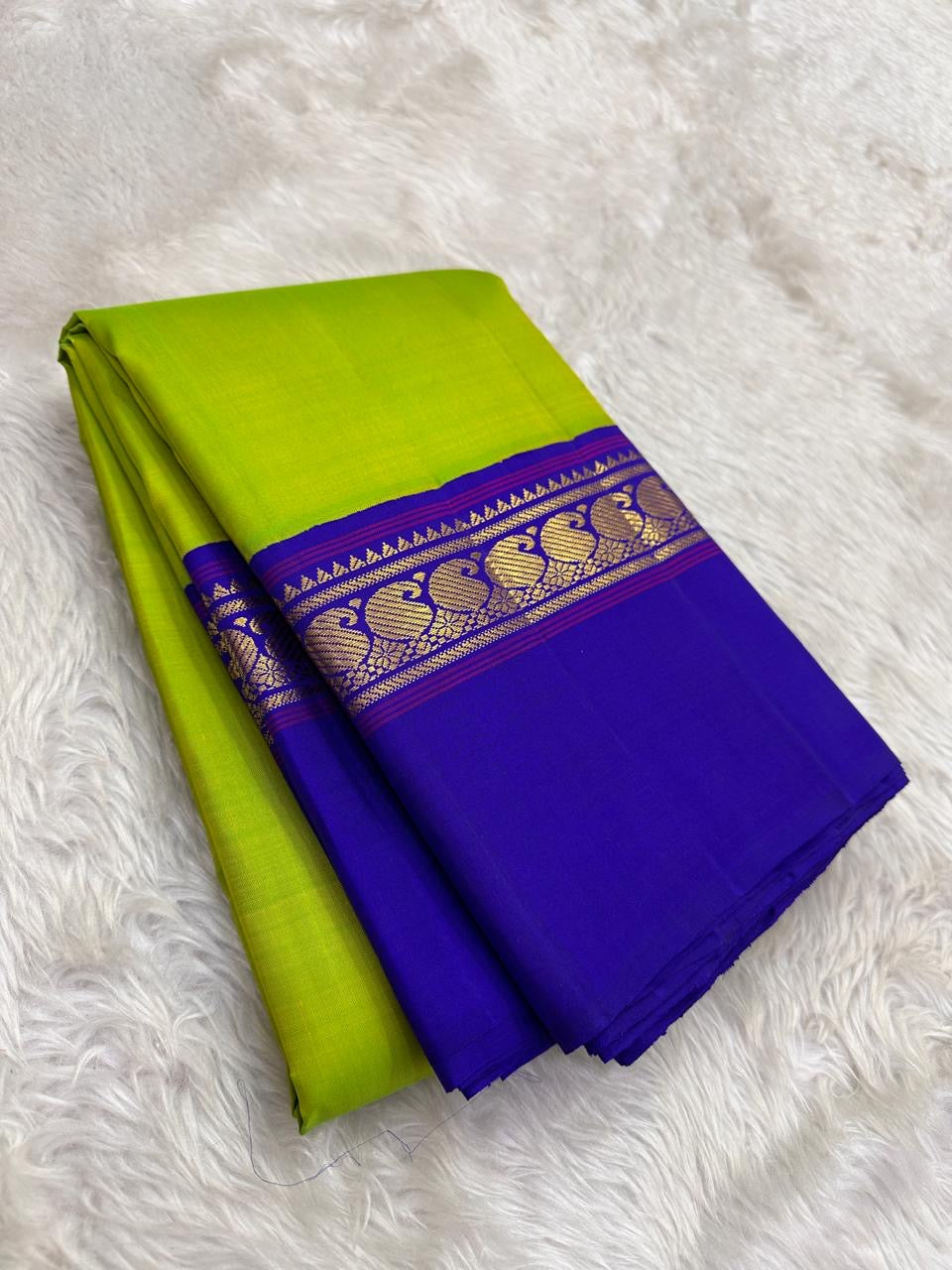 Pallu detail of lime green and violet pure silk Kancheepuram saree showing antique gold zari Mayil peacock motifs in Kaal Irangiya border
