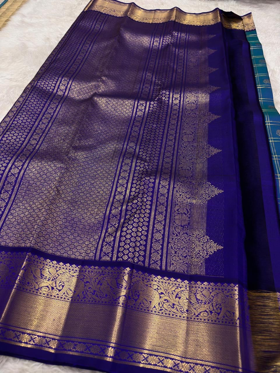 Deep violet Kancheepuram saree border with dense antique gold zari Yaanai elephant procession and scrolling floral forms — handwoven pure silk Idam Living