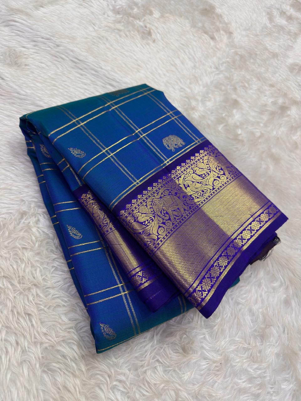 Pallu of peacock blue and violet Kancheepuram silk saree — grand antique gold zari Yaanai motifs on deep violet ground with layered zari band detailing